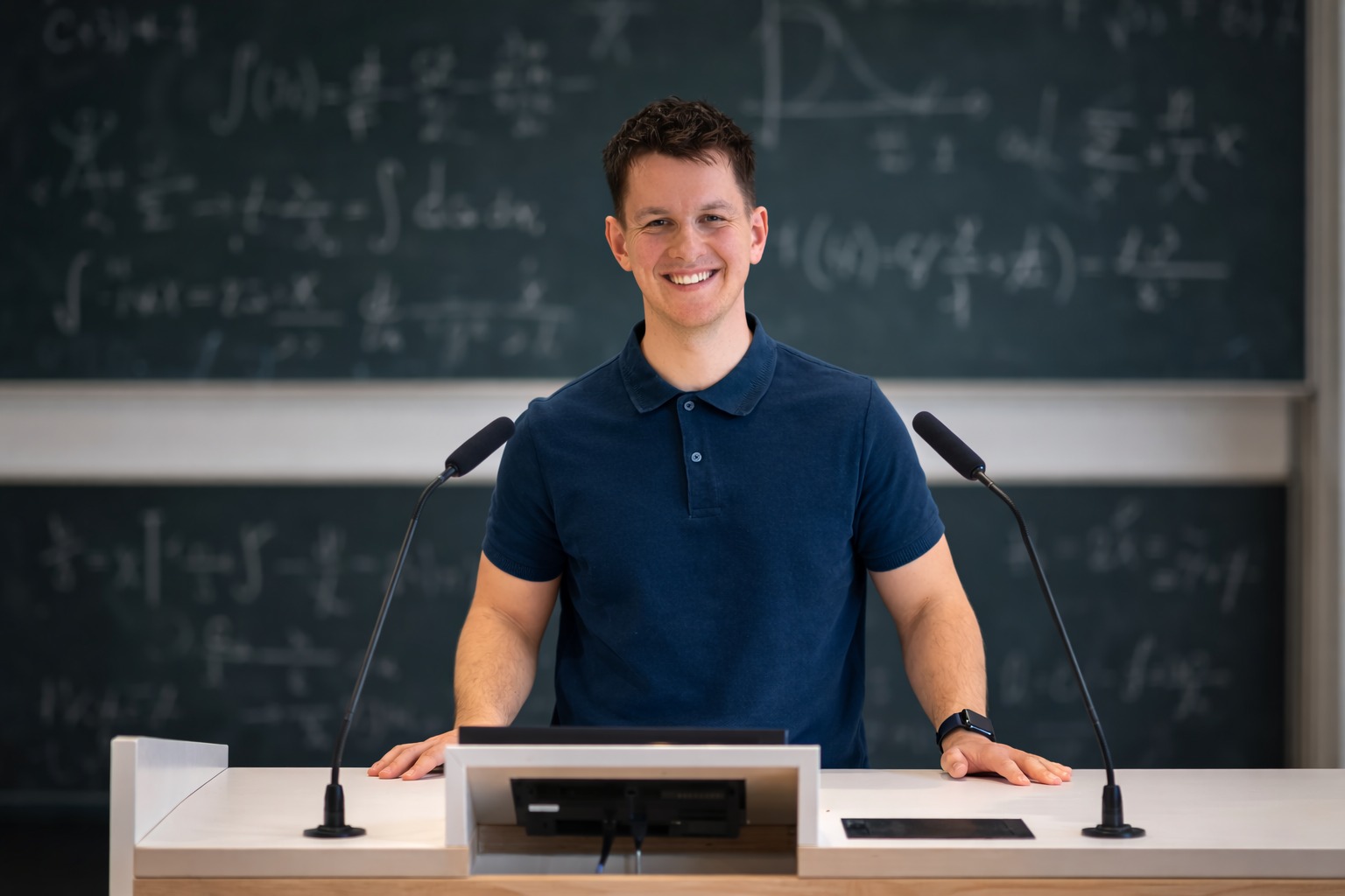 Portrait of Robert Josef Domogalla speaking at a lectern